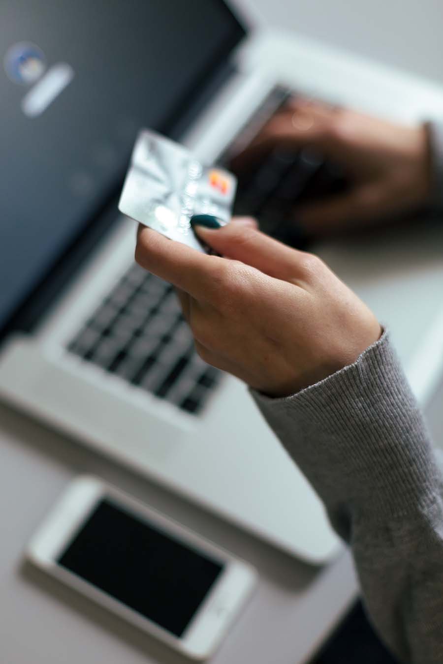 Person entering card info on computure. Freedom CU helps you stay safe while shopping with fraud alerts, transaction verification, and other tools to safeguard your account.
