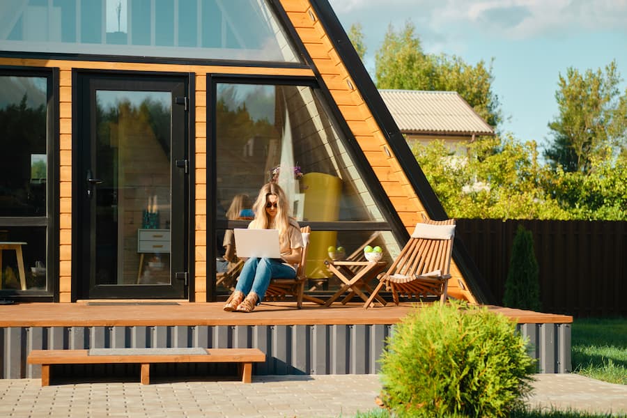 Woman sitting on the porch of an a-frame cabin